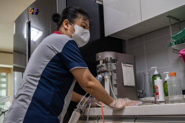 3년차 방문점검원 LG 케어솔루션 소속 매니저 신현정(49)씨가 고객 자택에서 정수기를 점검하고 있다.