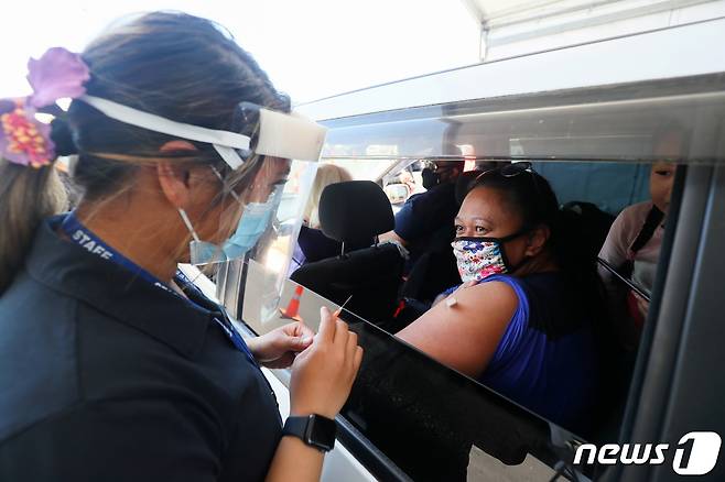 16일(현지시간) 뉴질랜드 오클랜드에서 한 여성 시민이 차 안에서 화이자 백신을 접종하고 있다. 2021.10.16 © 로이터=뉴스1