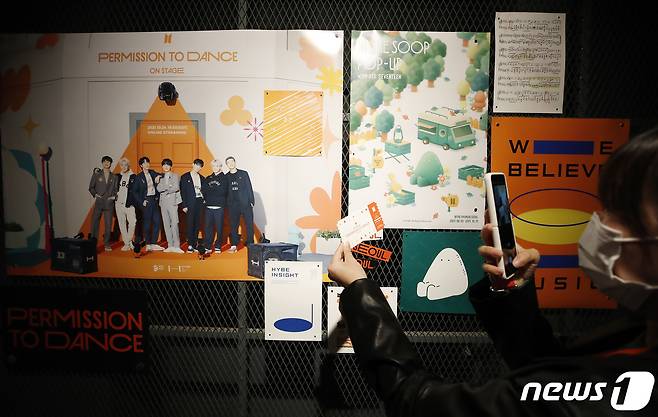 25일 서울 성수동에 마련된 방탄소년단의 오프라인 팝업스토어 ‘BTS 팝업:퍼미션 투 댄스 인 서울’을 방문한 한 팬이 티켓을 들고 기념 촬영을 하고 있다, 이번 팝업스토어는 방탄소년단이 지난 7월 공개한 '퍼미션 투 댄스' 뮤직비디오에서 사용된 오렌지색과 주요 장면을 재구성함으로써 밝고 자유로운 분위기의 공간으로 꾸며졌다. 또 지금까지 방탄소년단이 발표한 앨범의 디스코그라피 전시와 공연 영상 등을 함께 즐길 수 있는 공간도 마련됐다. 2021.10.25/뉴스1 © News1 권현진 기자