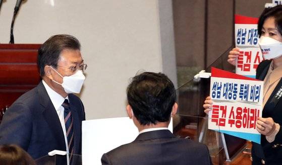 문재인 대통령이 25일 오전 국회 본회의장에서 2022년도 예산안 시정연설을 마치고 회의장을 나서는 동안 국민의힘 의원들이 대장동 관련 특검 수용을 요구하는 피켓을 들고 있다. 임현동 기자
