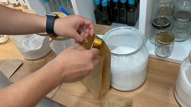 서울 강남구 소재 제로 웨이스트 상점 ‘덕분애’에서 매니저가 천연 세정제를 종이봉투에 담고 있다.