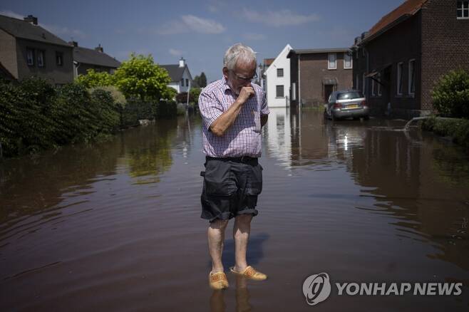 지난 7월 네덜란드 한 도시에서 한 주민이 홍수에 잠긴 자택 밖에 서 있다. [AP 연합뉴스 자료사진]