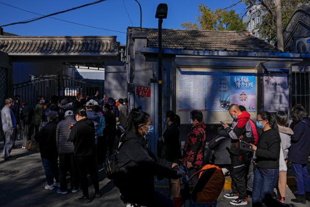 중국 베이징의 주택가 인근 코로나19 백신 접종소에서 22일 마스크를 쓴 주민들이 부스터샷을 맞기 위해 기다리고 있다. 베이징=AP 뉴시스