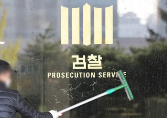 On October 22 when the investigation into the Daejang-dong development project was ongoing, a janitor wipes the glass wall at the Seoul Central District Prosecutors’ Office in Seocho-dong. Seoul. Yonhap News