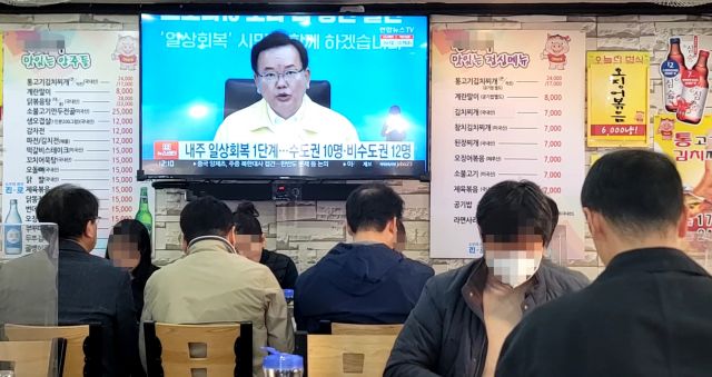 29일 서울 시내의 한 식당에 설치된 TV에 내달 1일부터 적용되는 단계적 일상회복 1단계 관련 뉴스가 나오고 있다. 연합뉴스