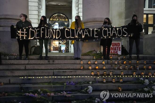 영란은행 인근 기후변화 시위 (런던 AP=연합뉴스) 시위대가 29일(현지시간) 런던 금융가에서 화석연료 금융지원 중단 촉구 시위를 벌인 뒤 영란은행 인근에서 촛불 행사를 하고 있다.photo@yna.co.kr 2021.10.30