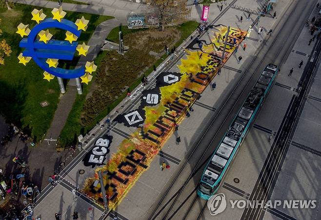 독일 프랑크푸르트 기후변화 시위 (프랑크푸르트 AP=연합뉴스) 시위대가 29일(현지시간) 유럽중앙은행(ECB) 앞에서 바닥벽화로 메시지를크게 적어두고 시위를 하고 있다. photo@yna.co.kr 2021.10.30