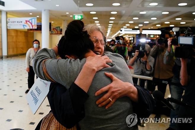 '이게 얼마 만이야' (시드니 로이터=연합뉴스) 한 여성이 시드니 공항에서 내린 뒤 마중 나와 있던 가족을 만나 얼싸안고 기뻐하고 있다. 2021. 11. 1 photo@yna.co.kr