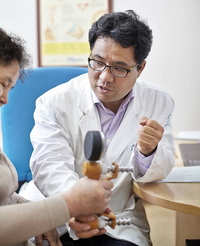 ◇노년기 근감소증은 다양한 질환을 예방할 수 있는 질병 개념으로 생각해야 한다. 강동경희대병원 재활의학과 유승돈 교수(오른쪽)가 환자의 악력을 검사하는 모습.