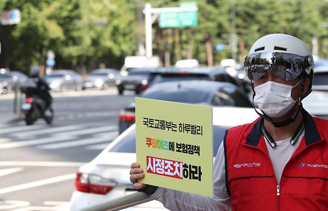 민주노총 서비스연맹 서비스일반노동조합원이 무보험 정책 변경을 요구하는 손피켓을 들고 있다. / 연합뉴스