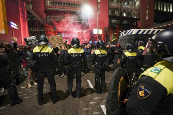 마르크 뤼터 네덜란드 총리가 12일(현지시간) 코로나19 봉쇄 조치를 재가동한다는 조치를 발표하는 동안 기자회견장 회부에 시위대가 모였다. 봉쇄 조치에 반발하는 시민들이 헤이그 시내에서 시위를 벌이자 현지 경찰들이 이들을 막아서고 있다. (사진=AFP)