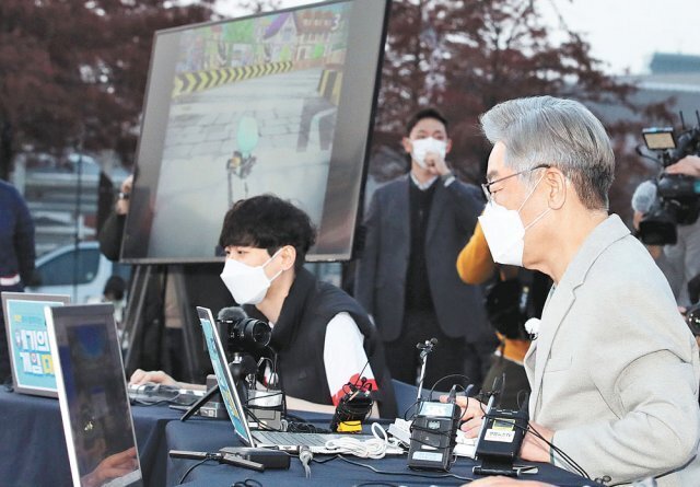 더불어민주당 이재명 대선 후보가 19일 대전 엑스포시민광장에서 ‘지스타 2021’을 알리기 위한 
행사로 프로게이머들과 게임을 하고 있다. 이 후보는 이번 주엔 ‘매타버스(매주 타는 민생 버스)’ 일정으로 충청 지역을 찾았다. 
대전=뉴스1