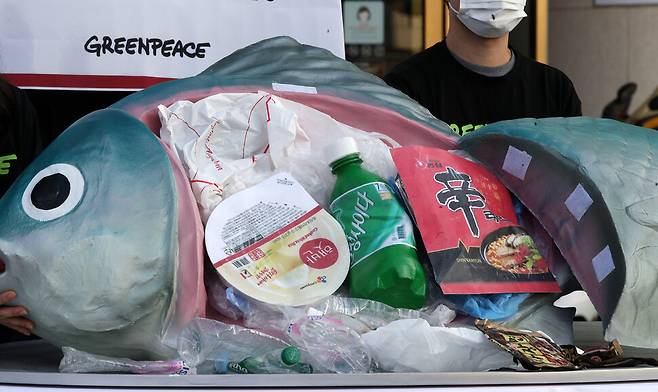 그린피스 활동가들이 길이 150㎝, 높이 90㎝의 대형 물고기 모형 배를 가르자 가정 내 플라스틱 쓰레기들이 나오고 있다. 김혜윤 기자
