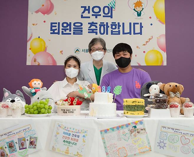 지난 9월 서울 아산병원에서 건우의 퇴원을 앞두고 건우와 부모, 주치의인 김애란(가운데) 교수가 사진을 찍었다. /서울 아산병원