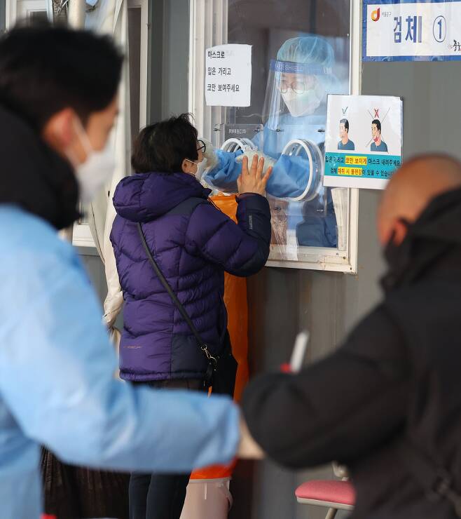 지난 26일 오전 서울역광장에 마련된 신종 코로나 바이러스 감염증(코로나19) 임시선별검사소를 찾은 시민이 검체 검사를 받고 있다. /연합뉴스