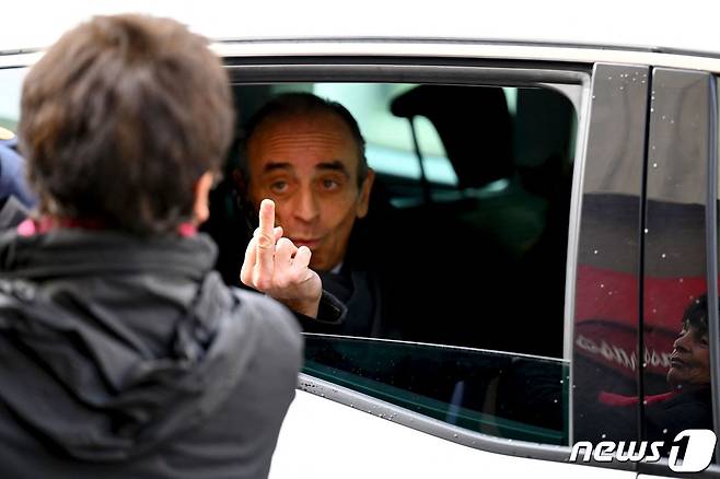 27(현지시간) 프랑스 남부 마르세유를 방문한 자리에서 행인에게 가운뎃손가락을 치켜들고 있는 에리크 제무르. © AFP=뉴스1