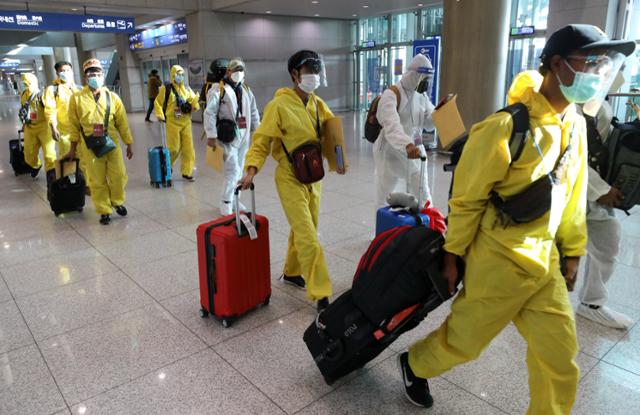 인천국제공항 제1터미널에서 29일 방호복을 착용하고 입국한 외국인들이 이동하고 있다. 인천공항=뉴시스