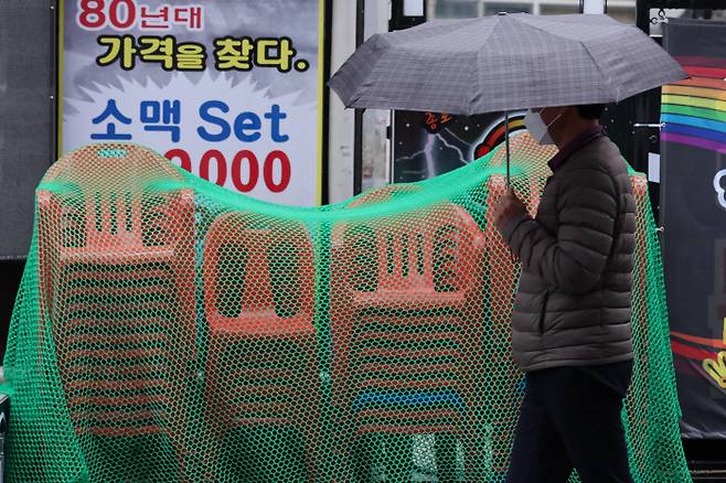 서울 종로의 한 식당가에 한 주점이 내놓은 간이 의자가 쌓여 있다. 코로나19 변이 바이러스인 ‘오미크론’이 세계적으로 유행할 조짐을 보이면서 위드 코로나 정책으로 잠시 회복세를 보이던 자영업이 다시 위축될 것으로 우려된다. 연합뉴스