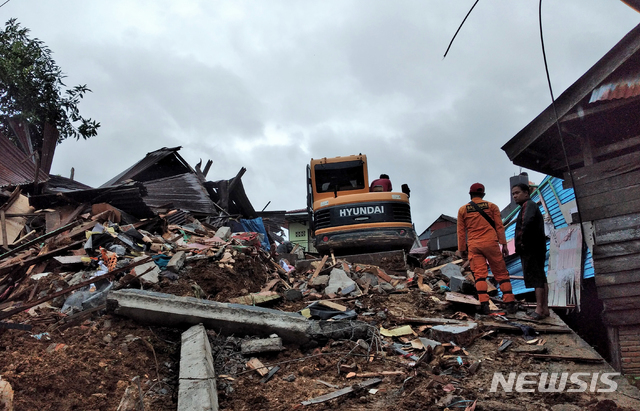 [마무주(인도네시아)=AP/뉴시스] 15일(현지시간) 인도네시아 술라웨시섬 마무주의 지진 피해 현장에서 구조대가 실종자 수색 작업을 벌이고 있다. 이날 새벽에 발생한 규모 6.2의 강진으로 지금까지 최소 34명이 숨지고 600명 이상이 부상을 입었다. 2021.01.15
