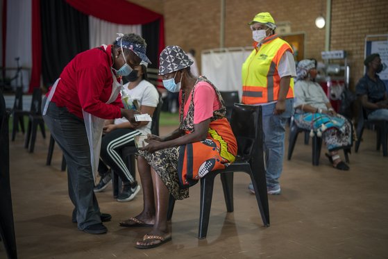 오미크론 변이 바이러스가 처음 보고된 남아프리카공화국의 한 오렌지 농장에서, 지역 주민들이 코로나19 백신을 맞기 위해 대기하고 있다. [AP=연합뉴스]