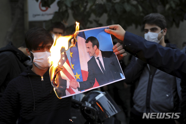 [테헤란=AP/뉴시스] 지난해 10월28일(현지시간) 이란 수도 테헤란의 프랑스 대사관 앞에서 에마뉘엘 마크롱 프랑스 대통령과 선지자 무함마드에 대한 만평에 항의하는 시위가 열려 시위대가 마크롱 대통령의 사진을 태우고 있다. 2020.10.29.