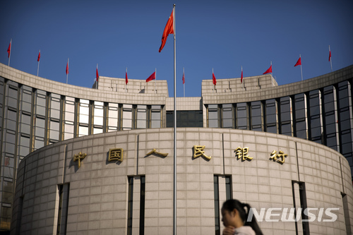 【베이징=AP/뉴시스】중국 중앙은행인 인민은행이 현금 수요가 급증하는 춘절(구정· 2월16일)를 앞두고 상업은행의 지급준비율(지준율)을 낮추는 조치를 취하기로 했다. 지난 3월10일 베이징 인민은행 본사 앞으로 행인들이 지나가고 있다. 2017.12.29