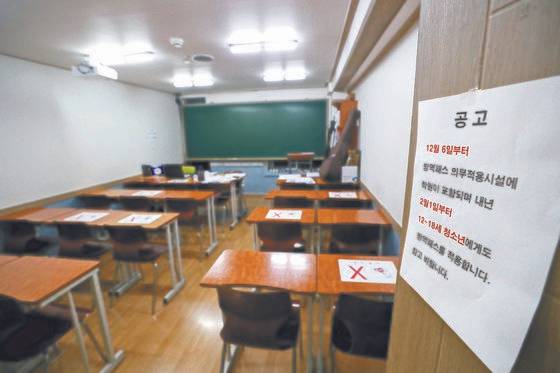 6일 오후 서울 시내의 한 학원에서 관계자가 방역패스 관련 안내문을 교실 등에 붙이는 모습. 뉴스1