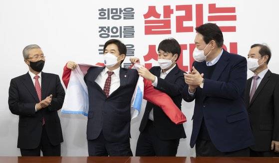 이준석 국민의힘 대표가 7일 오후 국회에서 열린 입당식에서 이용호 의원에게 당점퍼를 입혀주고 있다. 임현동 기자/20211207