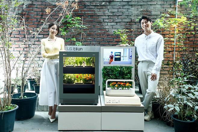 서울 성수동에 위치한 복합문화공간 플라츠에 15일부터 11월 초까지 운영하는 신개념 식물생활가전 LG 틔운(LG tiiun) 팝업스토어인 틔운 하우스에서 모델들이 LG 틔운과 LG 틔운 미니를 체험하고 있다.