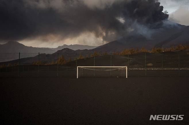 [라팔마=AP/뉴시스] 6일(현지시간) 스페인 카나리아제도 라팔마섬의 쿰브레 비에하 화산에서 용암이 흘러나오면서 축구장이 온통 검은 재로 뒤덮여 있다. 2021.12.08.