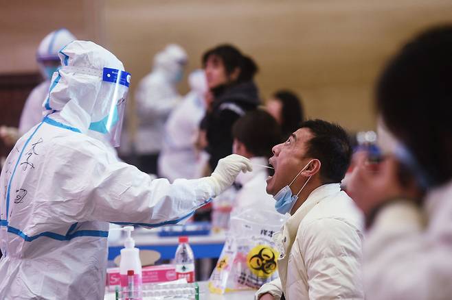 중국 항저우에서 의료진이 코로나19 검사를 위해 서비스업 종사자의 검체를 채취하고 있다. 저장성에서는 전날 하루에만 45명의 신규 감염자가 발생해 지난 5일 이후 누적 확진자 수는 250여 명으로 늘어났다.