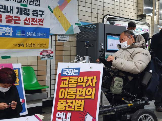 15일 서울 종로구 혜화역에서 진행된 장애인 이동권 선전전에서 이규식씨가 발언 중인 전국장애인차별철폐연대 회원을 바라보고 있다. 전혼잎 기자