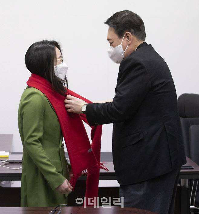 윤석열 국민의힘 대선후보(오른쪽)가 20일 서울 여의도 새시대 준비위원회 위원장실에서 열린 영입인사 환영식에서 신지예 한국여성정치네트워크 대표에게 빨간 목도리를 둘러주고 있다 (사진=방인권 기자)