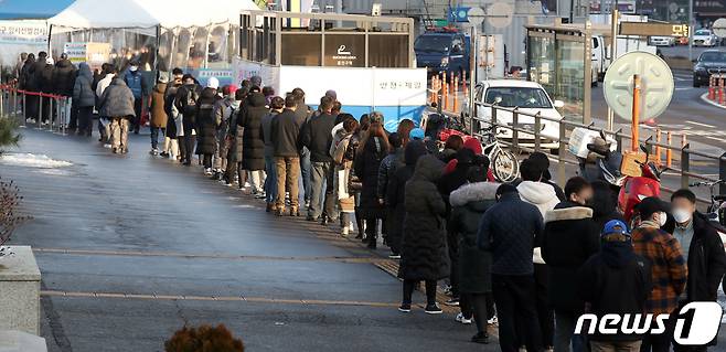 20일 오전 서울 중구 시청 앞에 마련된 신종 코로나 바이러스 감염증(코로나19) 서울광장 임시선별검사소에서 시민들이 검사를 받기 위해 줄지어 서 있다. 2021.12.20/뉴스1 © News1 김명섭 기자