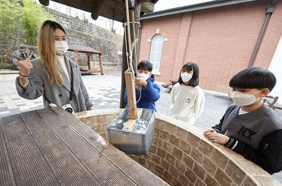 정경진 해설사(맨 왼쪽)와 함께 우물에서 두레박으로 직접 물을 퍼올리는 체험을 한 소중 학생기자단.