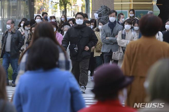 [도쿄(일본)=AP/뉴시스]지난달 29일 일본 도쿄에서 코로나19 감염 예방을 위해 마스크를 착용한 시민들이 횡단보도를 건너고 있다. 2021.12.20.