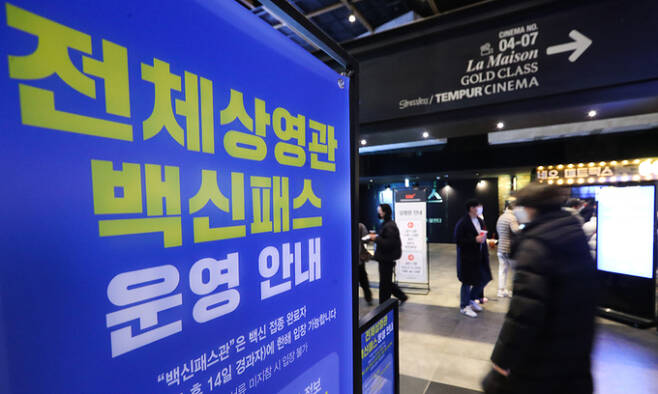 지난 19일 서울 시내 한 영화관에서 관람객들이 백신패스를 인증한 뒤 상영관에 입장하고 있다. 연합뉴스