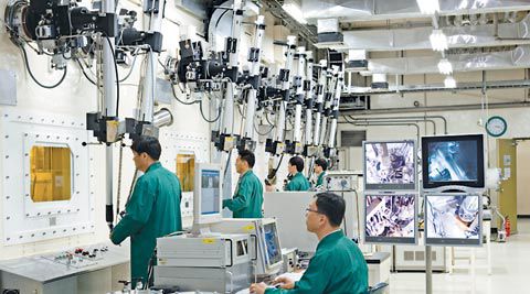 대전 한국원자력연구원에 있는 파이로 프로세싱 연구실에서 연구원들이 로봇팔로 방사능 차폐장치 내부에 있는 폐연료봉을 조작하고 있다./한국원자력연구원