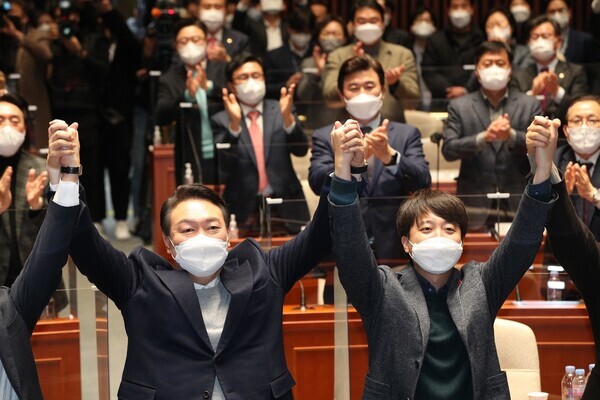 윤석열 국민의힘 대선 후보(왼쪽)와 이준석 대표가 6일 저녁 국회에서 열린 의원총회에서 손을 맞잡고 있다. 공동취재사진
