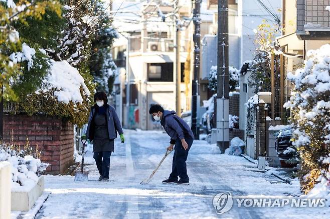 눈 내린 도쿄 모습 (도쿄 AFP=연합뉴스) 7일 일본 도쿄의 주택가에서 주민들이 도로의 눈을 치우고 있다.