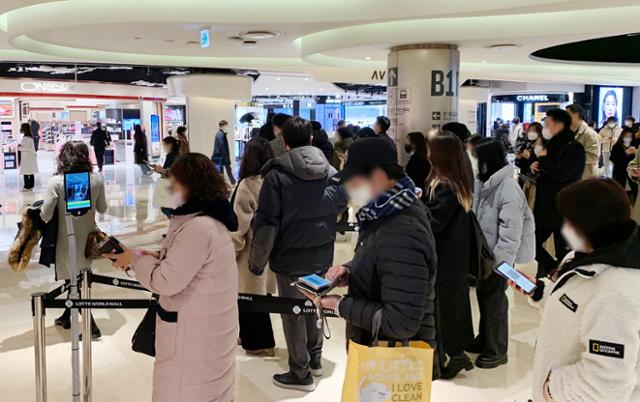 9일 서울의 한 백화점 출입구에서 휴대폰으로 출입 인증을 하기 위해 시민들이 줄을 서 있다. 연합뉴스