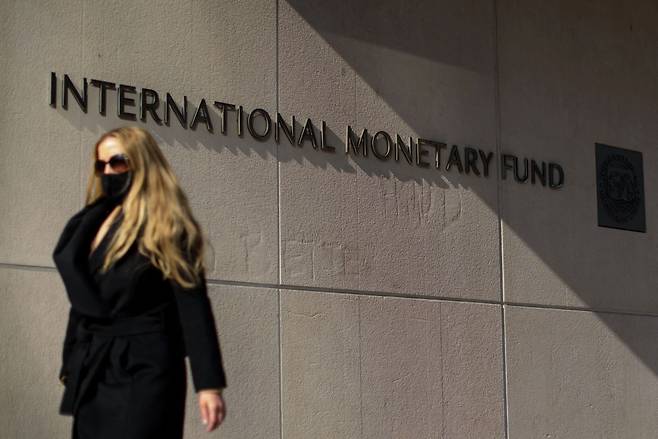 미국 워싱턴DC의 국제통화기금(IMF) 본부 앞을 한 여성이 지나가고 있다./AFP 연합뉴스