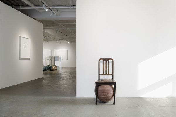 행성처럼 생긴 돌 위 청동의자 작품 `세상의 의자`가 전시장 입구에 놓여 있다.