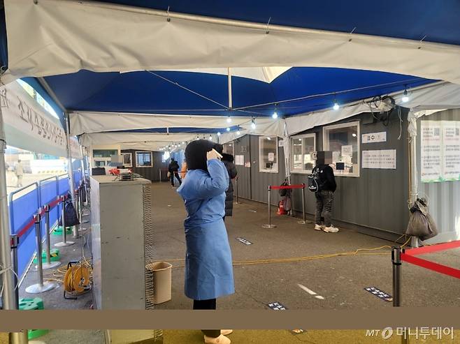 12일 오전 11시쯤 서울역광장 임시선별검사소 의료진이 대형 난로 옆에서 추위를 녹이고 있어. /사진=이사민 기자