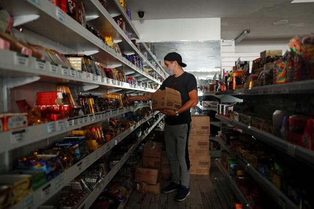 폭염으로 인한 전력 수요 급증으로 전기가 끊긴 아르헨티나의 수도 부에노스아이레스의 한 상점에서 11일 상점 주인이 상품을 진열하고 있다. 부에노스아이레스=로이터 연합뉴스