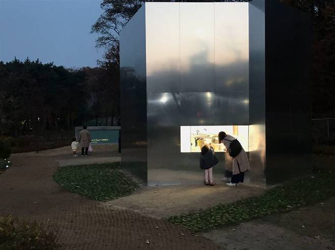 '턴 디포' 창을 통해 보관된 실험예술작품을 주민이 바라보고 있다.