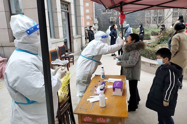 중국 허난성의 안양에 신종코로나바이러스감염증(코로나19) 봉쇄 조치가 내려진 가운데 지난 12일 외출이 제한된 한 주택단지의 입주자들이 3차 핵산 검사를 받고 있다. [연합]
