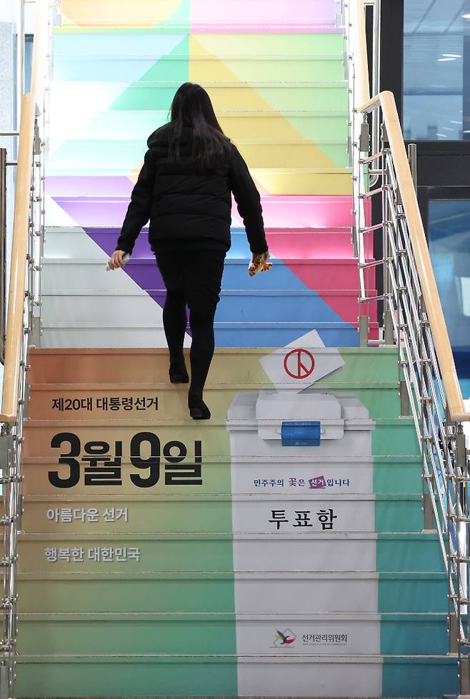 경기 과천시 중앙선거관리위원회에서 직원이 선거 홍보 문구와 그림이 래핑 처리된 계단을 오르고 있다. 연합뉴스