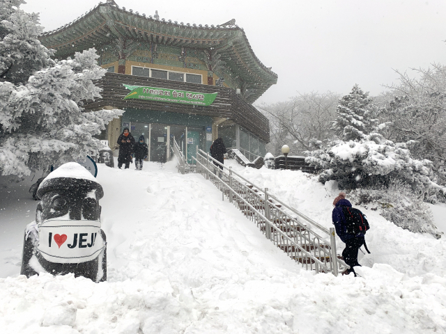 제주도 산지에 많은 눈이 내린 13일 한라산 1,100고지를 찾은 관광객들이 설경을 감상하고 있다. 이날 제주 산간에는 5cm 이상의 눈이 내리며 대설주의보가 내려졌다. /제주=연합뉴스