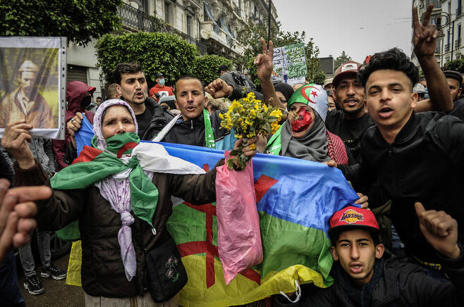 지난해 2월 알제리의 수도 알제에서 사람들이 압델라지즈 부테플리카 전 대통령의 장기 독재를 끝낸 민중운동인 ‘히락’ 2년을 기념하는 행사에서 ‘베르베르 깃발’을 펼쳐 보이고 있다. 연합뉴스